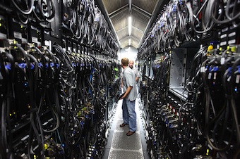 Microsoft Bing Maps' datacenter by Robert Scoble Two people talking to one another in a data center hallway about one person wide with bunches of racks and cabling on either side